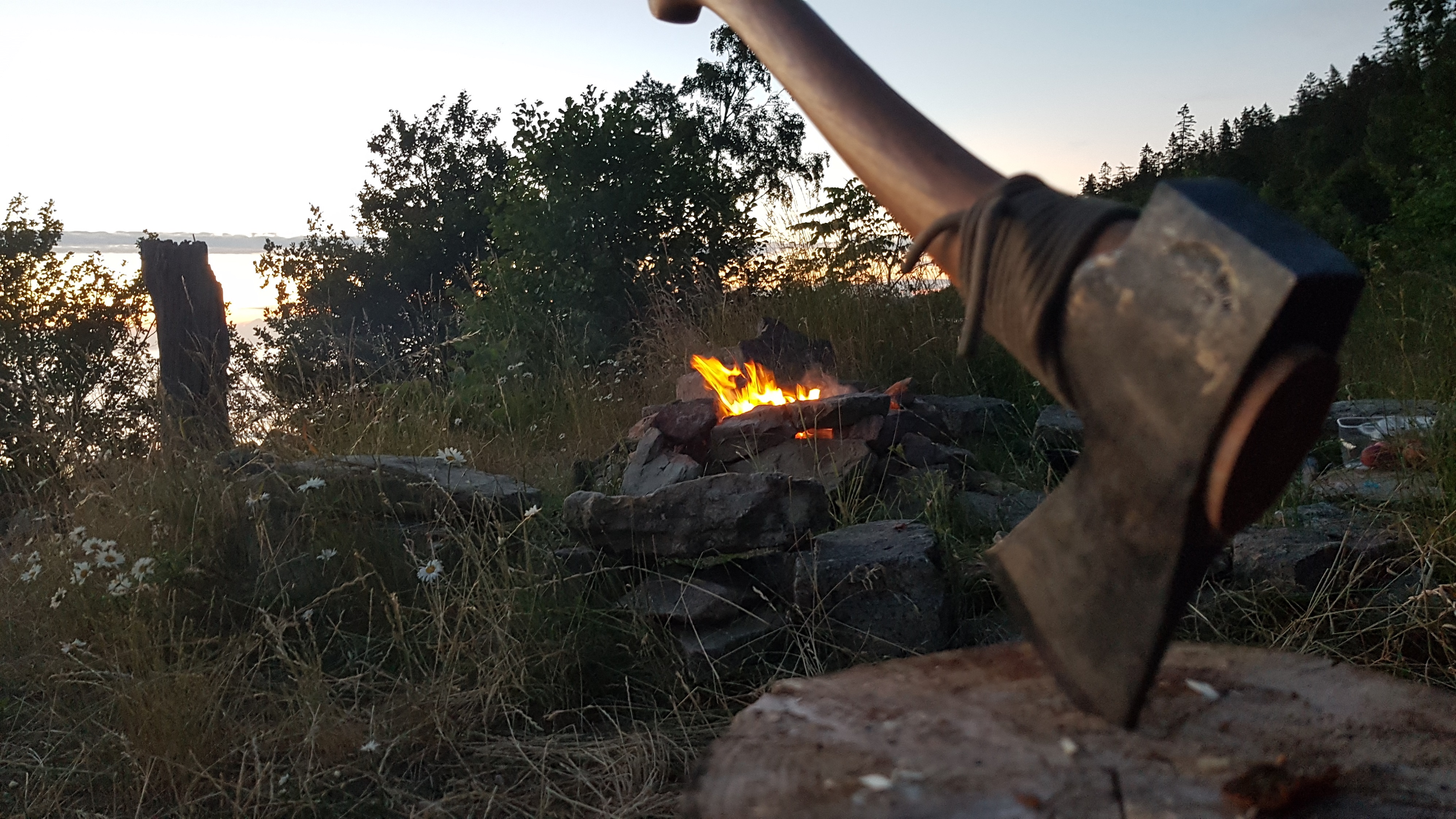 Lagerfeuer mit Beil im Vordergrund