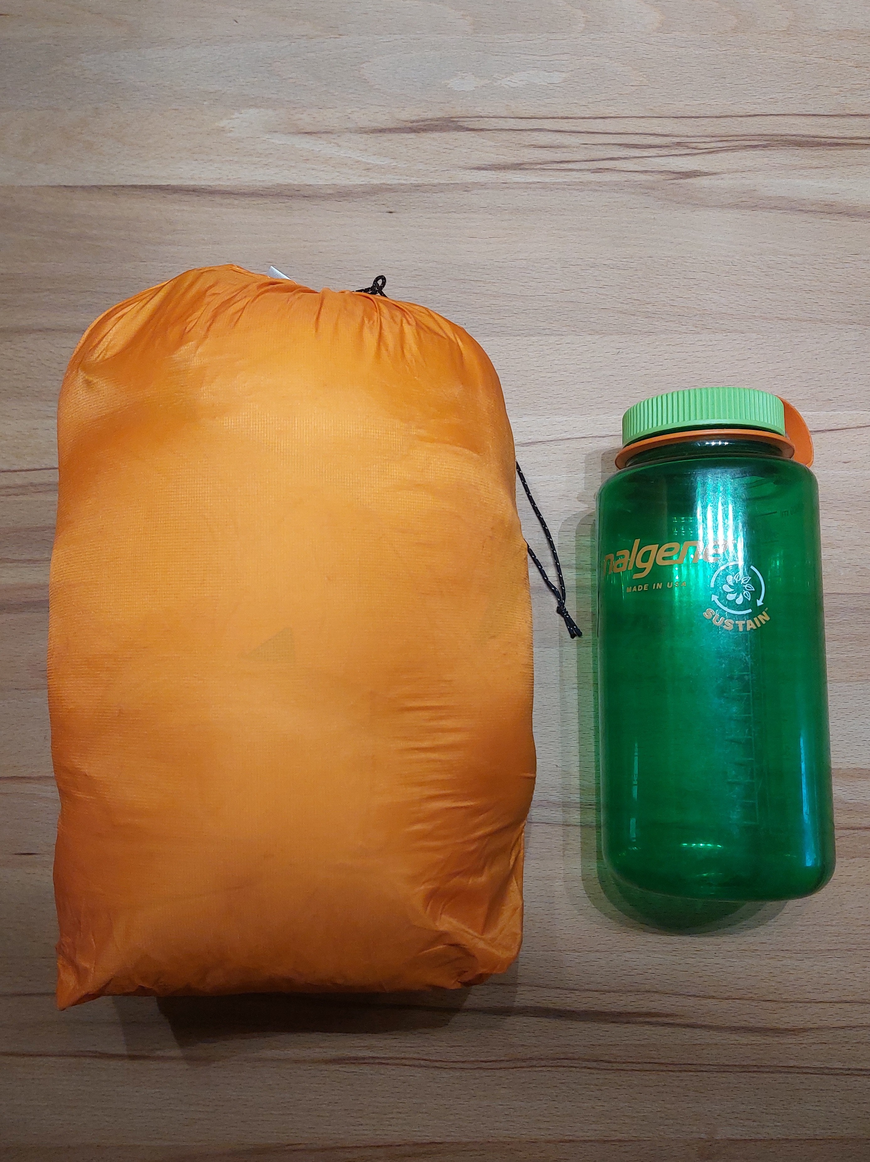 Die Jacke im Packsack im Vergleich zu einer 1L Nalgene-Flasche