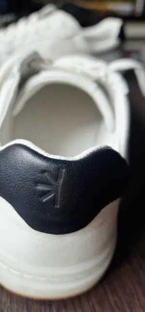 Schwarze Elemente unterstreichen den Sneakerlook.