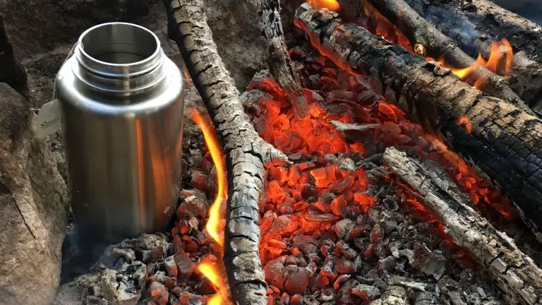Flasche im Lagerfeuer auf einer Wandertour in Schweden
