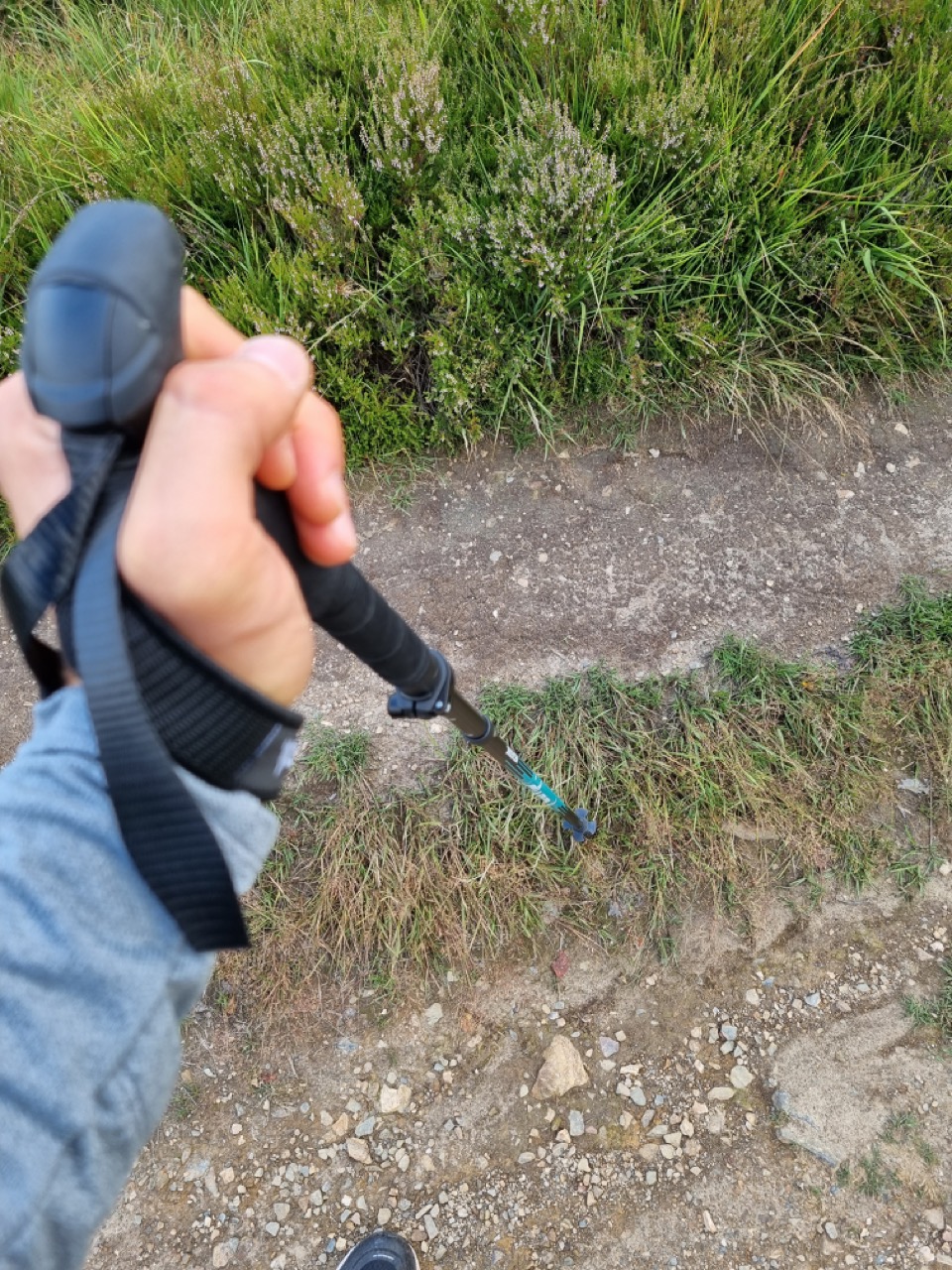 Wanderstock an der Hand befestigt.