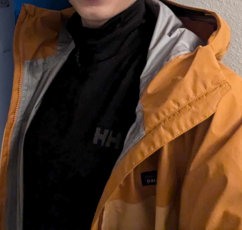Man sieht die Jacke unter einer Regenjacke 