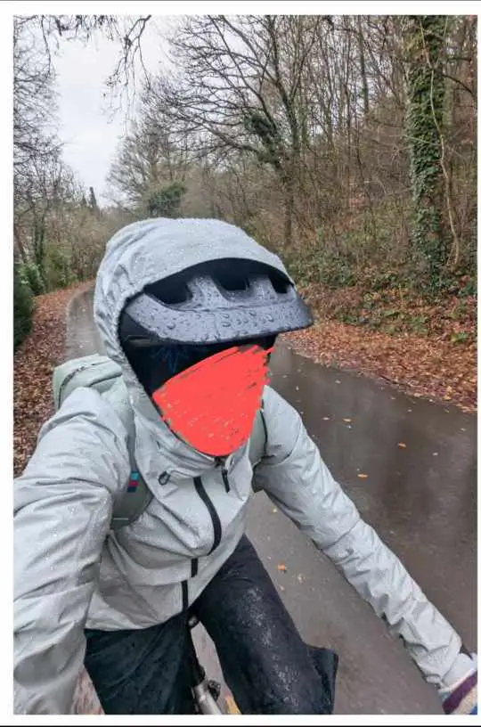 Man sieht jemanden im Regen mit der Jacke 