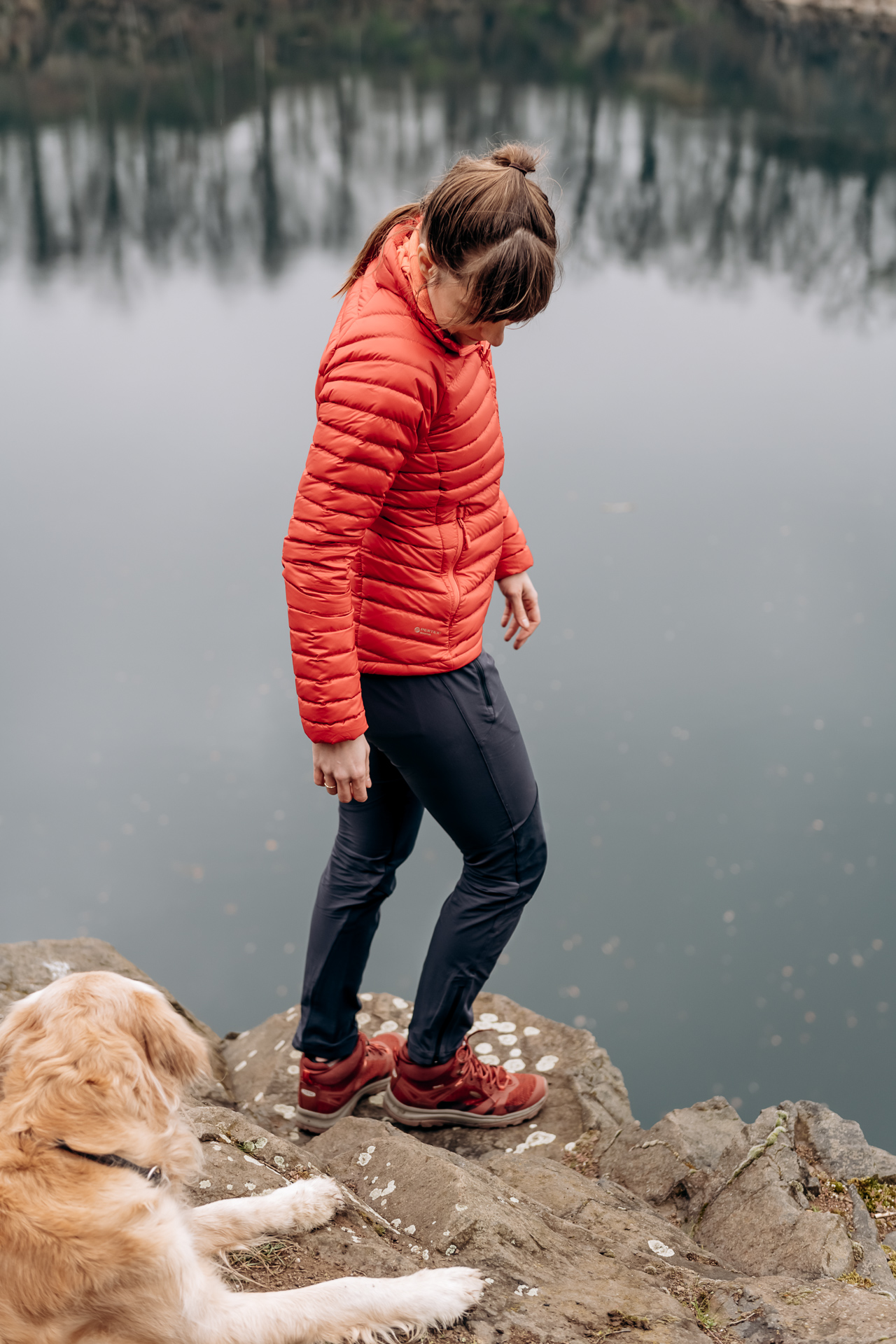 Frau mit Hund am Steinbruch beim Wandern