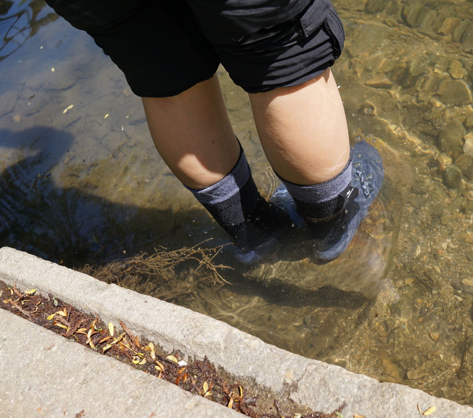 beide Füße im Fluss - Wasser unterhalb der Bündchen